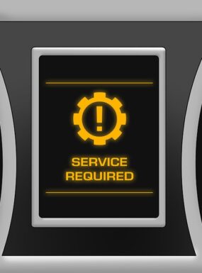 Car dashboard displaying a yellow ‘Service Required’ warning light icon